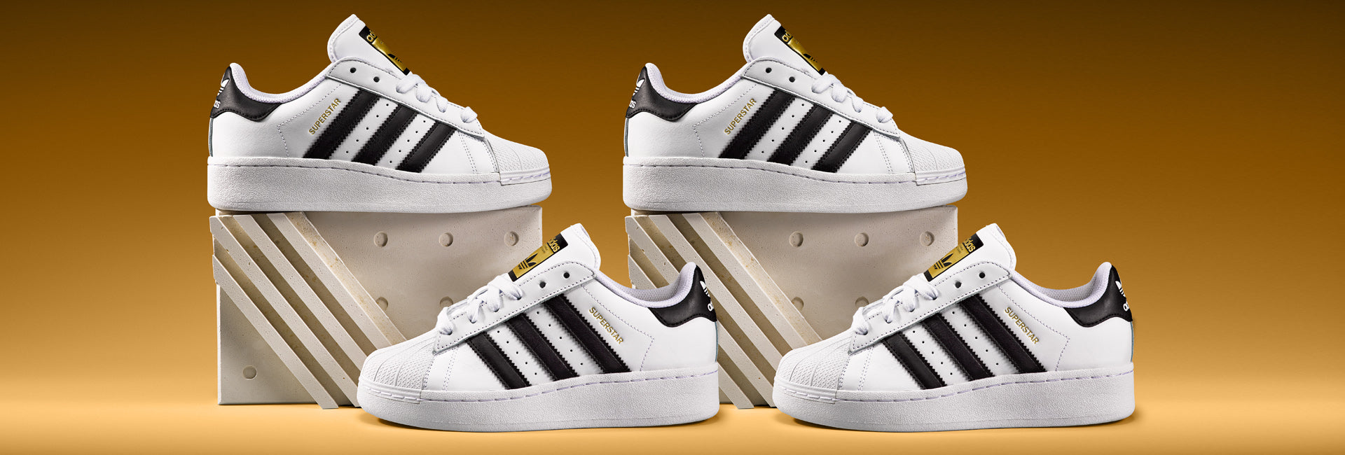 Adidas Superstar in weiss schwarz auf orangem Hintergrund