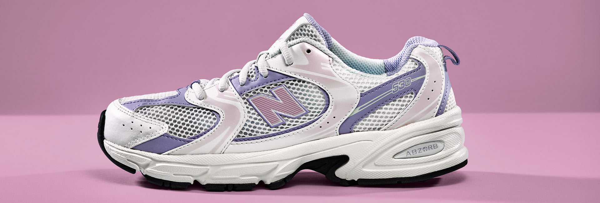 New Balance 530 Light Pink vor pinkem Hintergrund
